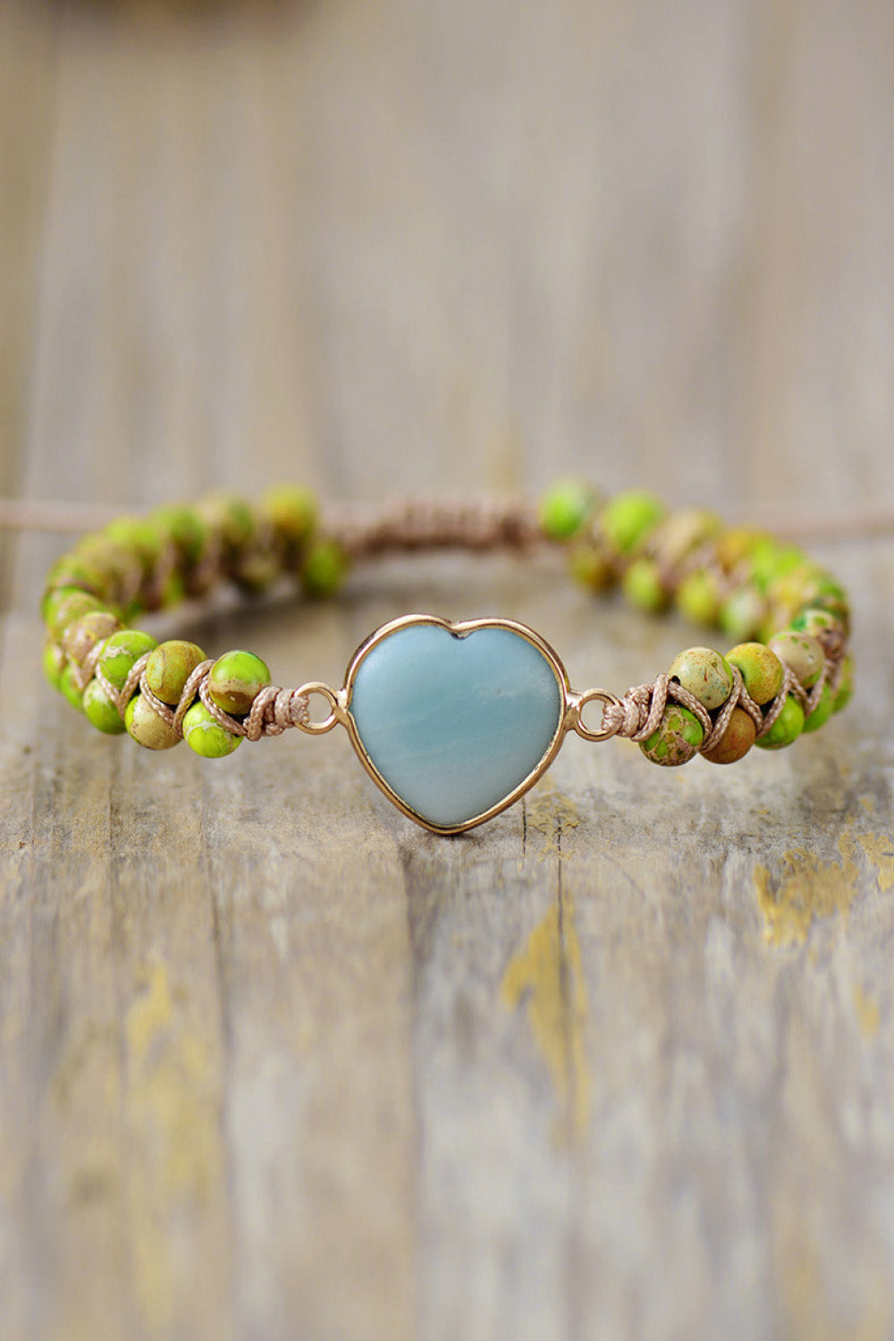 Bracelet with green beads and a heart-shaped turquoise stone on a wooden surface